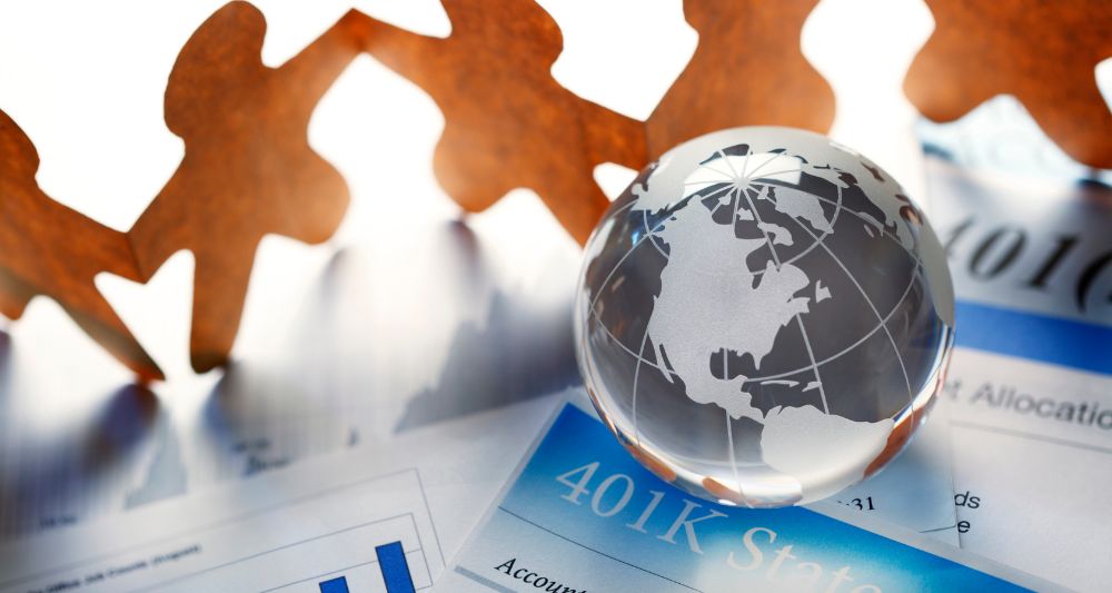 Imagen de un globo terráqueo de cristal sobre documentos financieros con gráficos utilizada en una entrada en el blog de Chapa Cambio sobre inversiones socialmente responsables