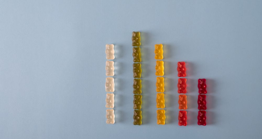 Imagen de ositos de goma organizados en columnas de diferentes colores, usada en una entrada en el blog de Chapa Cambio sobre la diversificación de carteras y la importancia de distribuir las inversiones