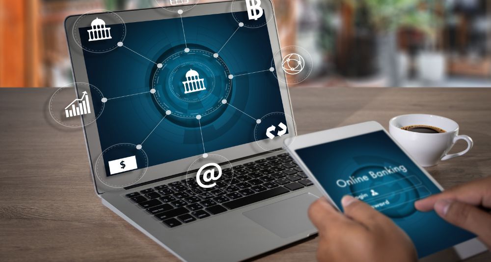 Imagen de una laptop y una tablet con gráficos de banca en línea, usada en una entrada en el blog de Chapa Cambio sobre bancos digitales y la evolución de la banca online