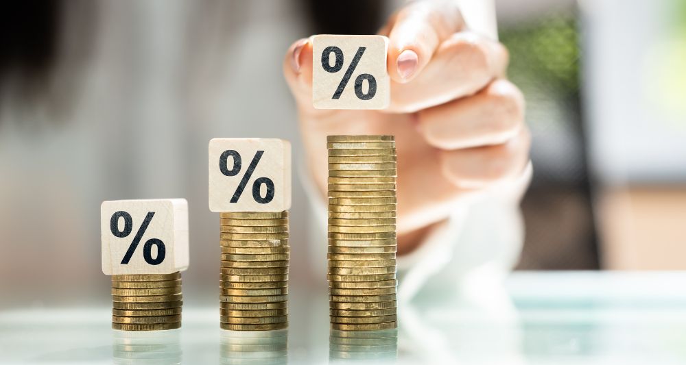 Portada utilizada en una nota del blog de Chapa Cambio que explica la importancia del interés simple, mostrando la progresión del crecimiento de una inversión a través de bloques con símbolos de porcentaje sobre pilas de monedas