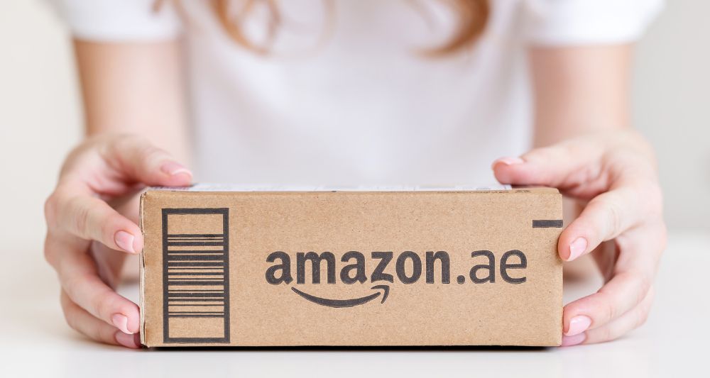 Foto utilizada en el blog de Chapa Cambio para una entrada sobre la rentabilidad de invertir en Amazon, mostrando un paquete con el logo de amazon.ae lo que nos habla del crecimiento y la popularidad de esta empresa en el mercado global